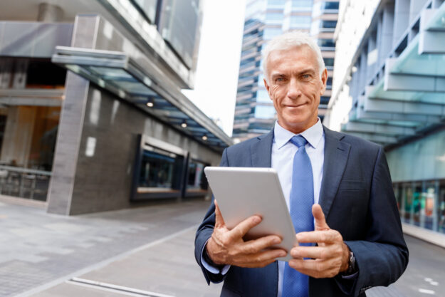 Senior businessman holding touchpad